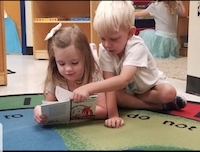 two kids reading a book